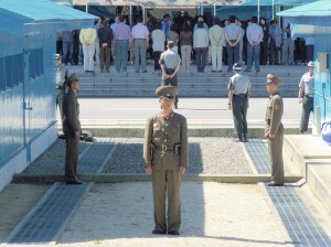 圖為駐守在板門店的北韓軍人（面對者）與南韓憲兵（背對者）。微微凸起的門檻即為軍事分界線。（網路圖片）