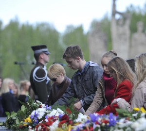 世界各地舉行活動紀念二戰勝利70週年，圖中青年向集中營遺址紀念碑獻花。（圖片來源：新華網）