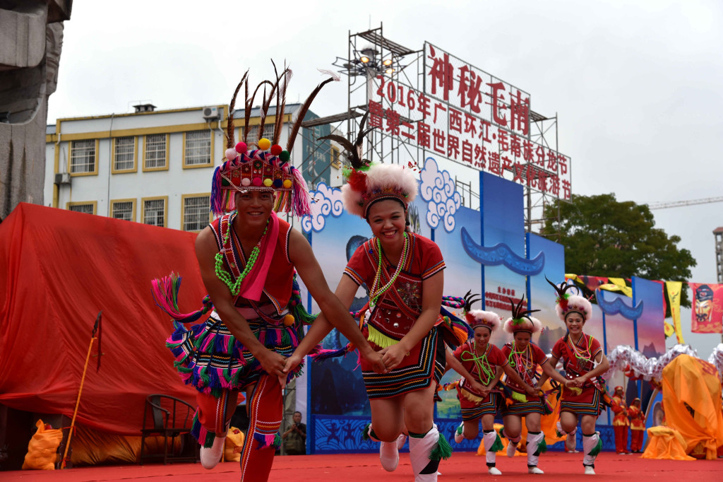 廣西環江毛南族分龍節開幕 6月18日，來自台灣的演員在分龍節開幕式上表演舞蹈。當日，2016年廣西環江毛南族分龍節開幕。毛南族群眾身穿民族盛裝，歡度毛南族古老、盛大的重要節日。節日期間將舉辦龍舟邀請賽、飄香環江美食節、神秘毛南儺面舞會、山歌表演、獅王英雄會等。分龍節是毛南族祈神保佑豐收的傳統節日，也是毛南族一年一度的重大活動。（新華社照片，高東風 攝，河池（廣西），2016年6月18日） 