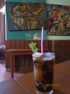 左上畫作中有一杯透明飲料和一杯深色飲調，將兩杯飲料調和一起即成為照片主角El Negrón。