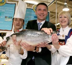 為了開拓中國大陸市場，挪威首相（中）在北京一超市內「推銷」來自挪威的鮭魚。（新華社 陳建力 攝）