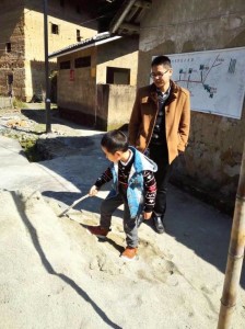 台灣醫生陳柏睿帶著孩子在土樓前玩耍。（新華社圖片）