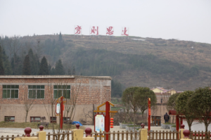 塘約村村委會小樓上，四個紅色大字：窮則思變。