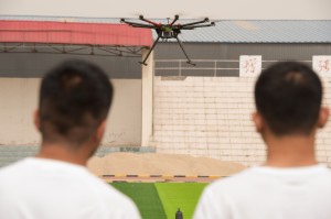 大學無人機專業的同學們在操場練習操控無人機按指定路線和姿態飛行。    （新華社 蒲東峰 攝）