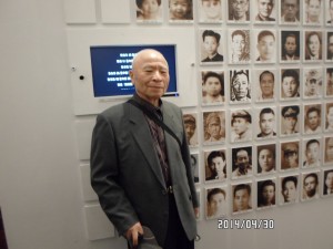 2014年4月，陳炳基在台北市南海路二二八紀念館裡與自己的照片合影。